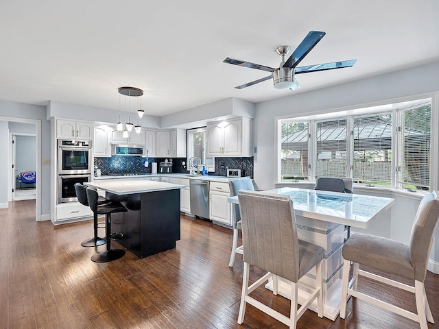 18118 Whitman Ln, Lansing, IL 60438 - kitchen with appliances with stainless steel finishes, white cabinetry, light countertops, and a kitchen island