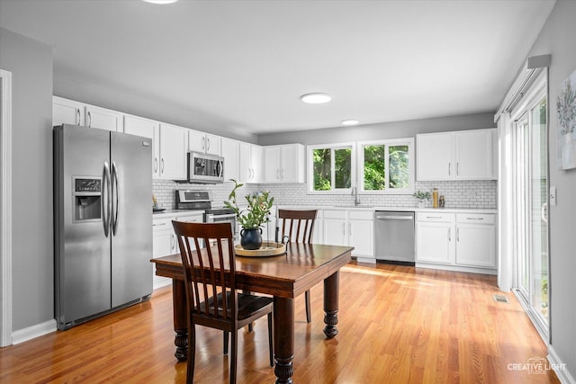 2164 Clementi Ln, Aurora, IL 60503 - kitchen with stainless steel appliances, light wood finished floors, decorative backsplash, and white cabinets
