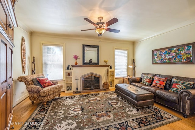 1823 N Newland Ave, Chicago, IL 60707 - living area featuring wood finished floors, a ceiling fan, a fireplace with raised hearth, healthy amount of natural light, and crown molding