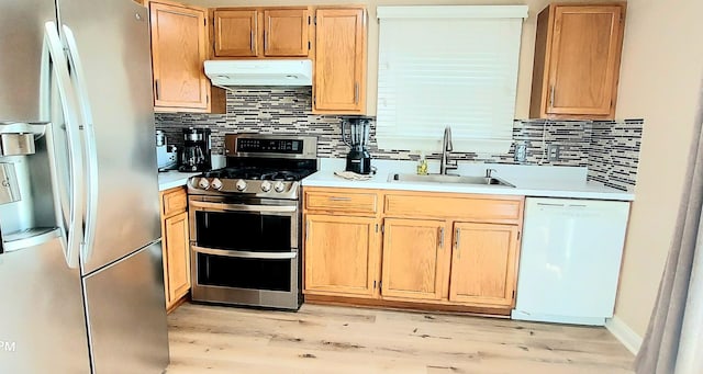 100 Hamlet Cir, Montgomery, IL 60538 - kitchen with appliances with stainless steel finishes, under cabinet range hood, light wood-style floors, light countertops, and decorative backsplash