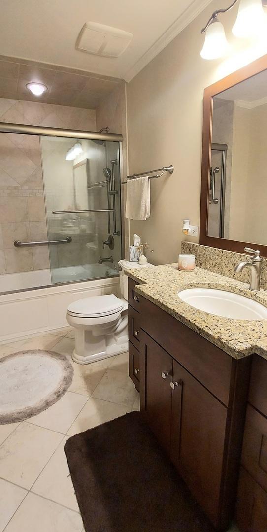 100 Hamlet Cir, Montgomery, IL 60538 - bathroom featuring crown molding, vanity, shower / bath combination with glass door, and tile patterned flooring
