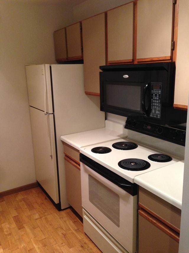 4305 W Shamrock Ln Unit 2F, Mchenry, IL 60050 - kitchen featuring white range with electric stovetop, black microwave, light wood-style floors, and light countertops