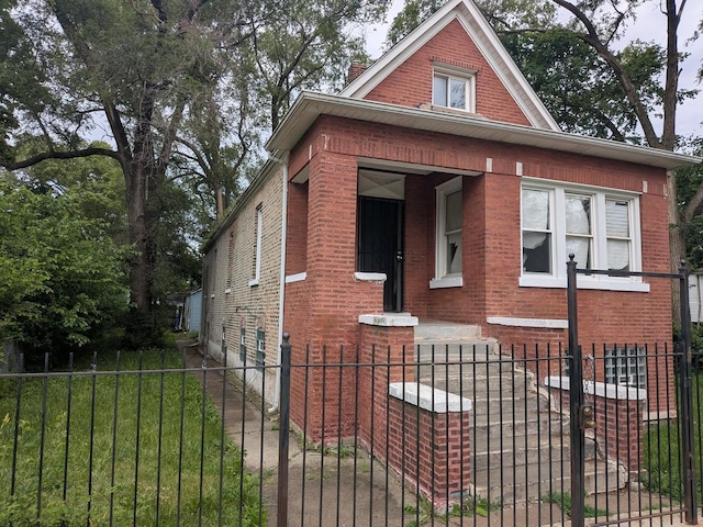 7017 S Hermitage Ave, Chicago, IL 60636 - bungalow-style house featuring brick siding, a fenced front yard, and a chimney
