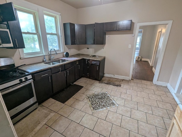 7017 S Hermitage Ave, Chicago, IL 60636 - kitchen with appliances with stainless steel finishes, dark cabinets, and light tile patterned flooring