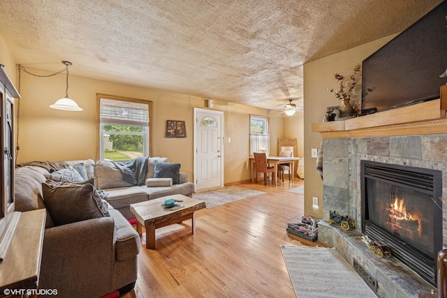 1316 Heidorn Ave, Westchester, IL 60145 - living room featuring a tiled fireplace, light wood finished floors, plenty of natural light, and a textured ceiling
