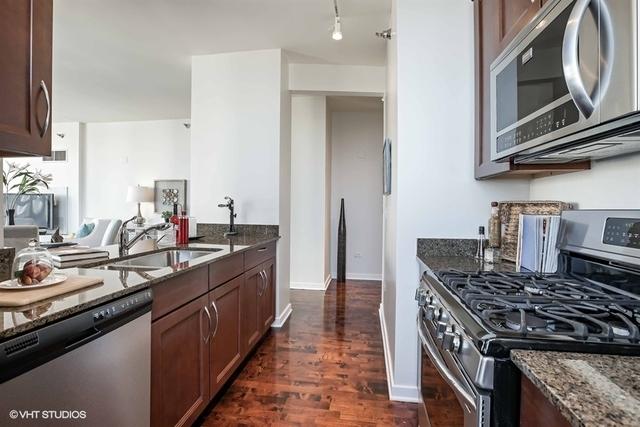 330 W Grand Ave Unit 2106, Chicago, IL 60654 - kitchen featuring stainless steel appliances, dark stone countertops, dark wood finished floors, and rail lighting