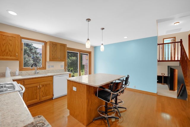 1860 Harvard Ln, New Lenox, IL 60451 - kitchen featuring white dishwasher, a center island, light wood finished floors, hanging light fixtures, and a kitchen bar