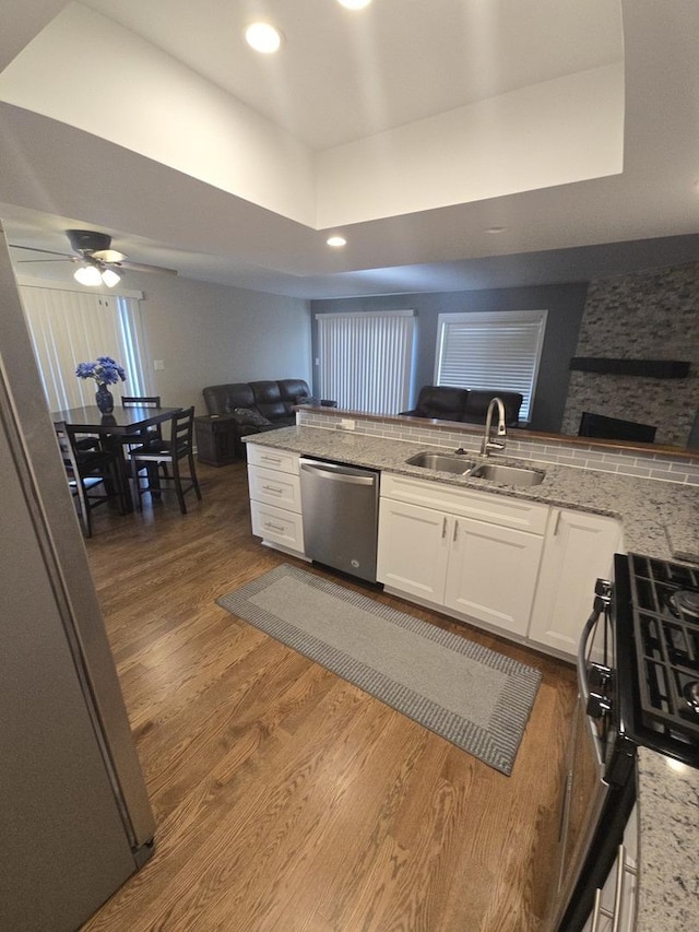8201 Daniel Dr, Justice, IL 60458 - kitchen featuring stainless steel dishwasher, open floor plan, white cabinetry, wood finished floors, and recessed lighting