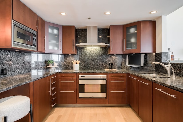 950 N Michigan Ave Unit 4502, Chicago, IL 60611 - kitchen with oven, stainless steel microwave, wall chimney exhaust hood, dark stone counters, and light wood-type flooring