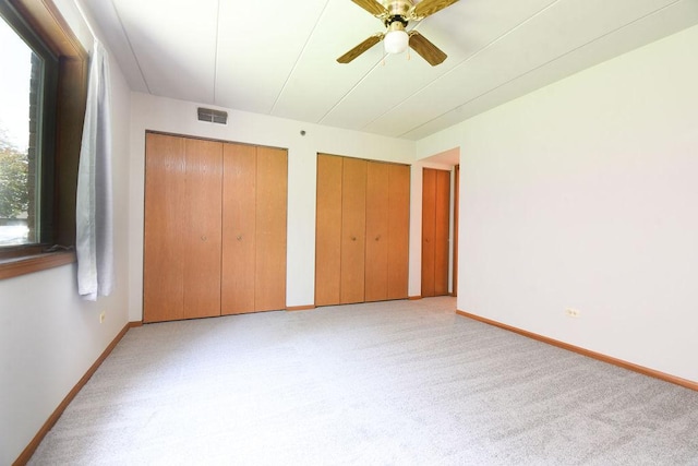 10278 SW Hwy Unit 1D, Chicago Ridge, IL 60415 - unfurnished bedroom featuring multiple closets, light carpet, and ceiling fan