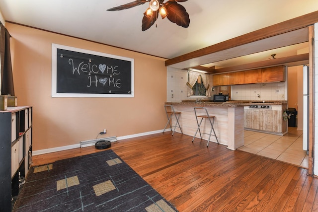 144 Crestwood Dr, East Dundee, IL 60118 - kitchen featuring wood finished floors, ceiling fan, backsplash, a peninsula, and black microwave