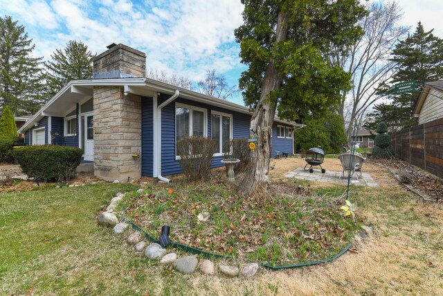 144 Crestwood Dr, East Dundee, IL 60118 - view of side of property with an outdoor fire pit, a chimney, and stone siding