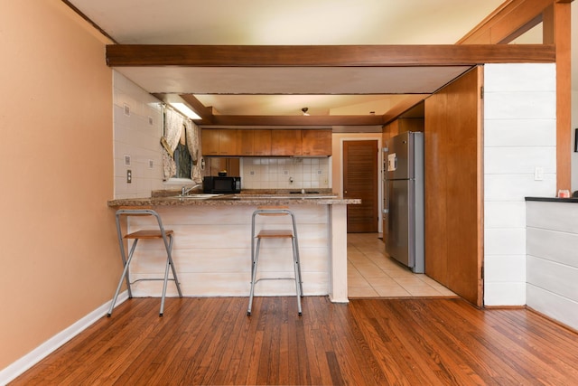 144 Crestwood Dr, East Dundee, IL 60118 - kitchen featuring freestanding refrigerator, a peninsula, black microwave, and wood finished floors