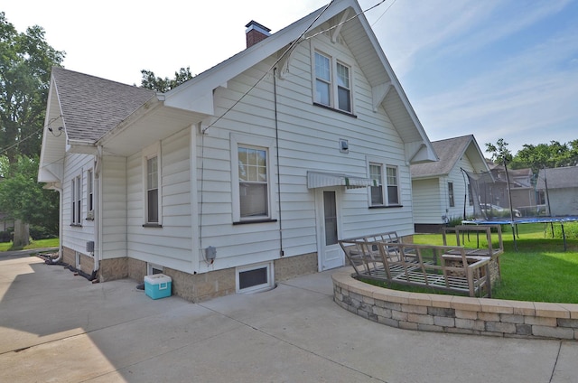 623 Marcy St, Ottawa, IL 61350 - back of property with a patio, a trampoline, a chimney, a yard, and roof with shingles
