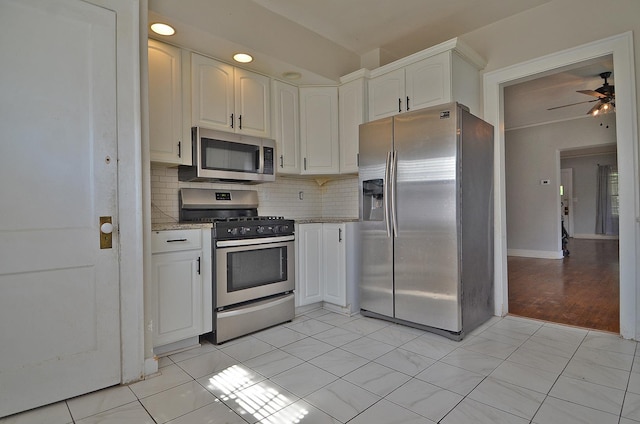 623 Marcy St, Ottawa, IL 61350 - kitchen with appliances with stainless steel finishes, decorative backsplash, white cabinets, ceiling fan, and light stone counters