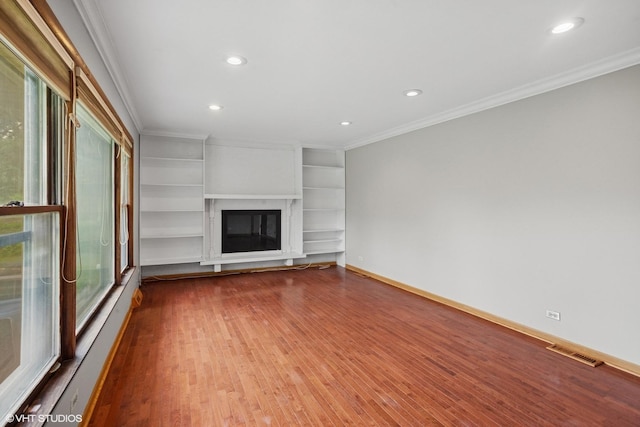 33 W Wise Rd, Schaumburg, IL 60193 - unfurnished living room with crown molding, wood finished floors, recessed lighting, a glass covered fireplace, and built in shelves