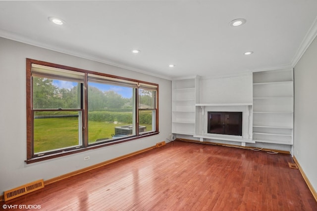 33 W Wise Rd, Schaumburg, IL 60193 - unfurnished living room with crown molding, hardwood / wood-style floors, recessed lighting, built in shelves, and a fireplace