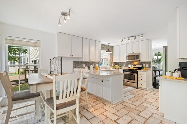 29583 N Birch Ave, Lake Bluff, IL 60044 - kitchen featuring stainless steel appliances, rail lighting, decorative backsplash, white cabinets, and light countertops