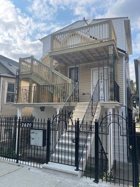 2620 W 24th St, Chicago, IL 60608 - view of front facade with stairway, a fenced front yard, a gate, and a balcony
