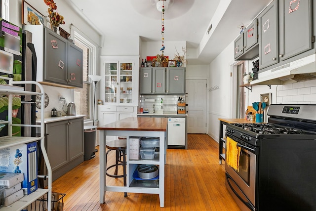 1624 N Oakley Ave, Chicago, IL 60647 - kitchen featuring stainless steel gas range oven, dishwasher, butcher block countertops, decorative backsplash, and under cabinet range hood