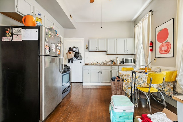 1624 N Oakley Ave, Chicago, IL 60647 - kitchen featuring appliances with stainless steel finishes, dark wood-style floors, tasteful backsplash, and white cabinetry