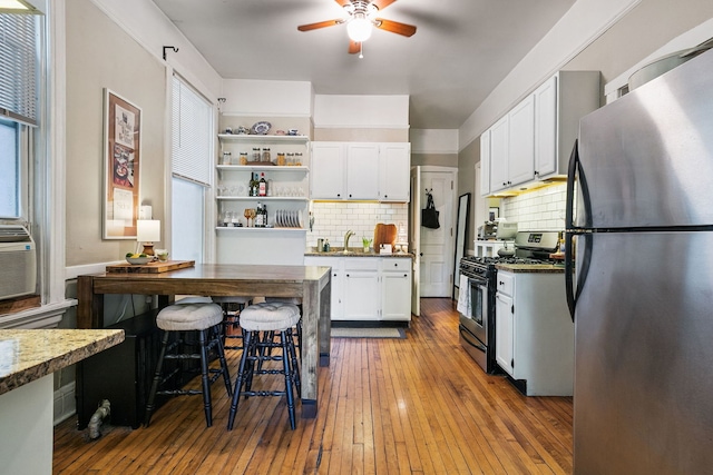 1624 N Oakley Ave, Chicago, IL 60647 - kitchen with stainless steel appliances, ceiling fan, white cabinets, open shelves, and backsplash