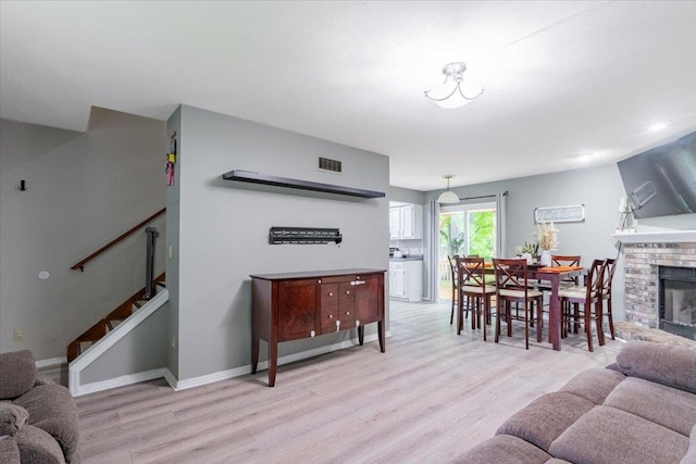 1311 Bancroft Dr, Bloomington, IL 61704 - living area featuring light wood-style flooring, a fireplace, and stairway