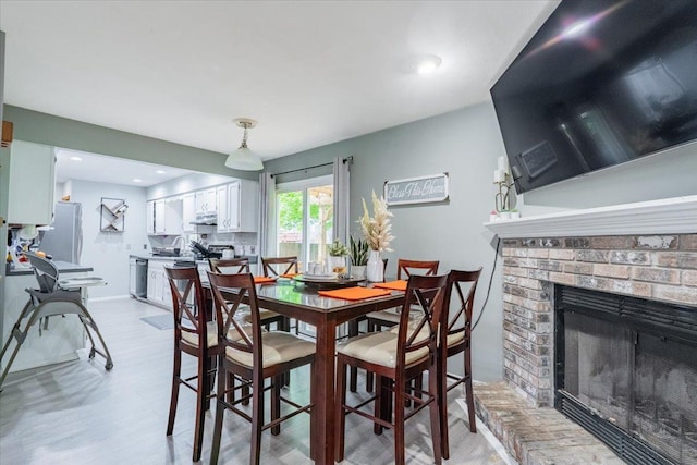 1311 Bancroft Dr, Bloomington, IL 61704 - dining area featuring light wood-style floors and a brick fireplace