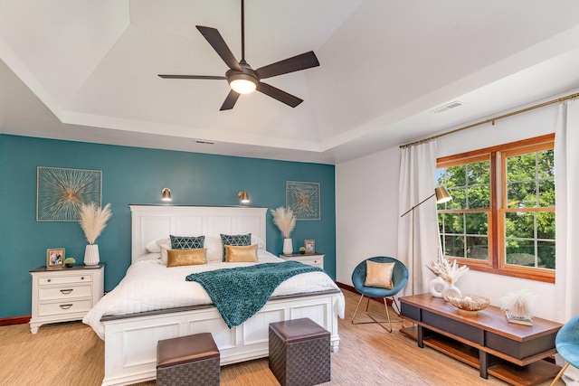 12114 W Castle Dr, Mokena, IL 60448 - bedroom featuring a raised ceiling, light wood-style floors, vaulted ceiling, and ceiling fan
