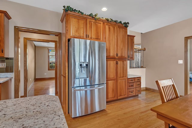 26645 W Ian Ct, Channahon, IL 60410 - kitchen with stainless steel fridge, light wood-style flooring, brown cabinetry, light stone countertops, and recessed lighting