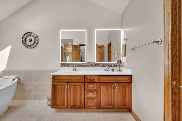 26645 W Ian Ct, Channahon, IL 60410 - full bathroom with vaulted ceiling, double vanity, tile patterned flooring, a freestanding bath, and tile walls