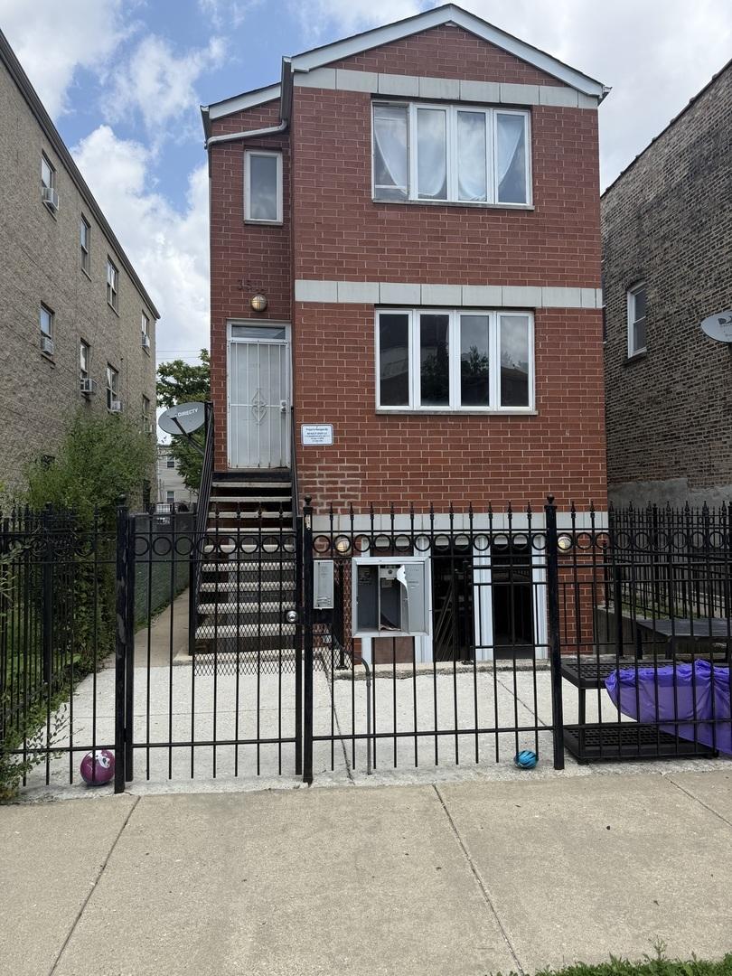 3518 W Lexington St, Chicago, IL 60624 - view of front facade with a fenced front yard and brick siding