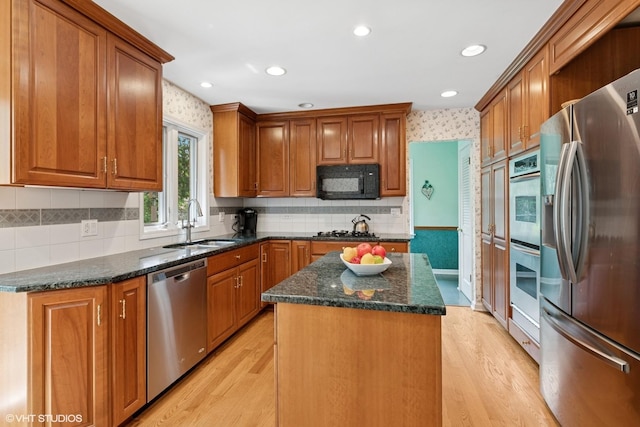 1329 Sanford Ln, Glenview, IL 60025 - kitchen featuring appliances with stainless steel finishes, a center island, brown cabinets, light wood finished floors, and recessed lighting