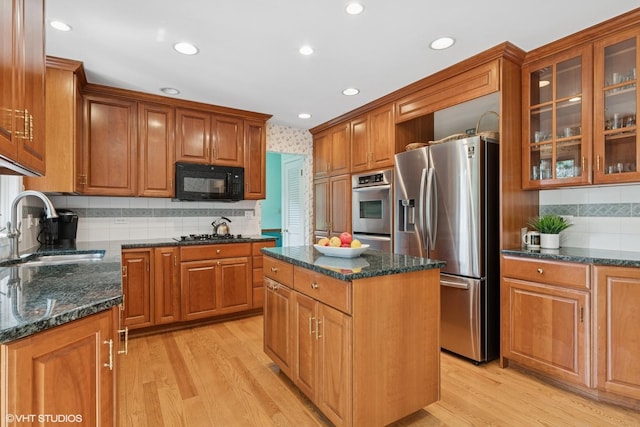 1329 Sanford Ln, Glenview, IL 60025 - kitchen with appliances with stainless steel finishes, backsplash, dark stone counters, brown cabinets, and light wood-type flooring