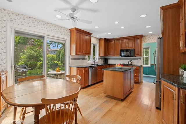 1329 Sanford Ln, Glenview, IL 60025 - kitchen with stainless steel appliances, wallpapered walls, a kitchen island, a ceiling fan, and plenty of natural light