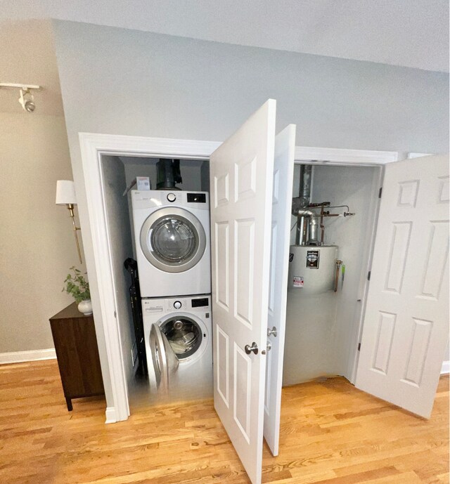 669 N Peoria St Unit 1N, Chicago, IL 60642 - washroom featuring stacked washing machine and dryer, light wood finished floors, and water heater