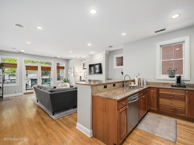 669 N Peoria St Unit 1N, Chicago, IL 60642 - kitchen with stainless steel dishwasher, brown cabinets, a peninsula, light stone counters, and light wood finished floors