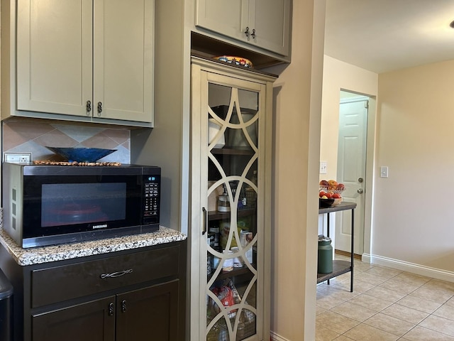 2417 Lyons St, Evanston, IL 60201 - bar featuring black microwave, light tile patterned flooring, and decorative backsplash