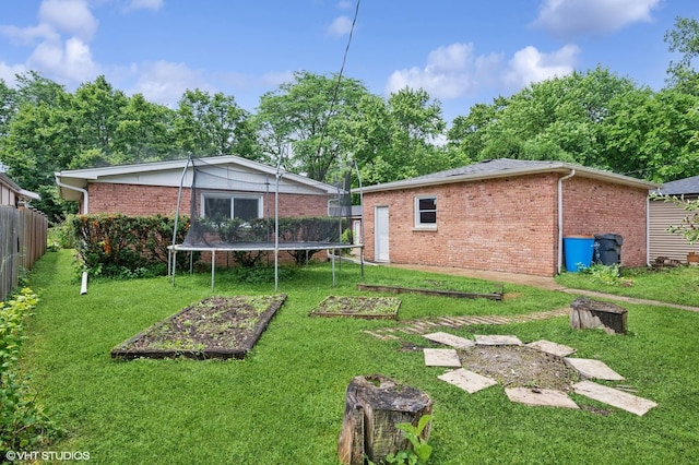 2417 Lyons St, Evanston, IL 60201 - rear view of house with brick siding, a vegetable garden, and a trampoline