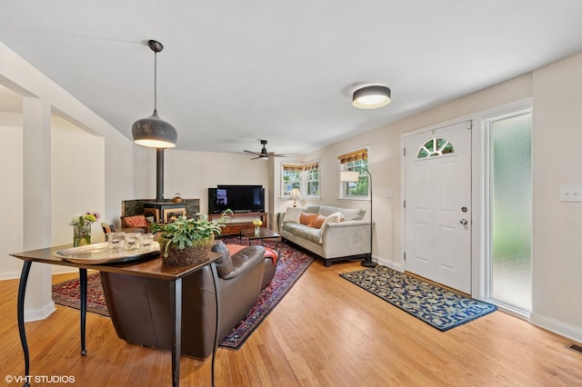 2417 Lyons St, Evanston, IL 60201 - living room featuring wood finished floors, ceiling fan, and a wood stove