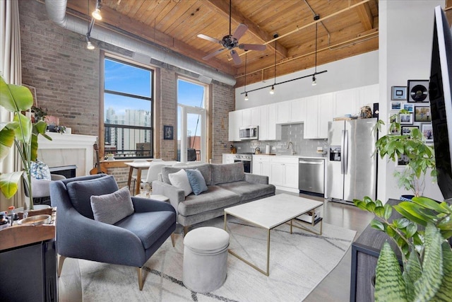 1801 S Michigan Ave Unit 701, Chicago, IL 60616 - living area with a high ceiling, a wooden ceiling with exposed beams, brick wall, track lighting, and ceiling fan