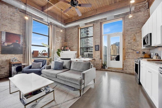 1801 S Michigan Ave Unit 701, Chicago, IL 60616 - living room with a wooden ceiling with exposed beams, brick wall, a high ceiling, wood finished floors, and ceiling fan