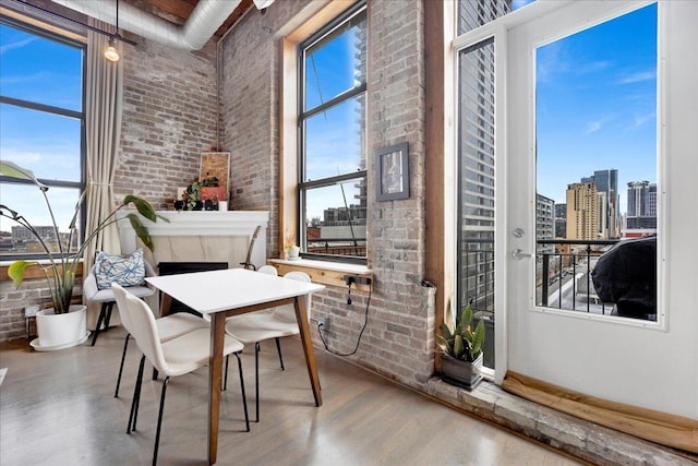 1801 S Michigan Ave Unit 701, Chicago, IL 60616 - dining space featuring brick wall, wood finished floors, a view of city, and a towering ceiling