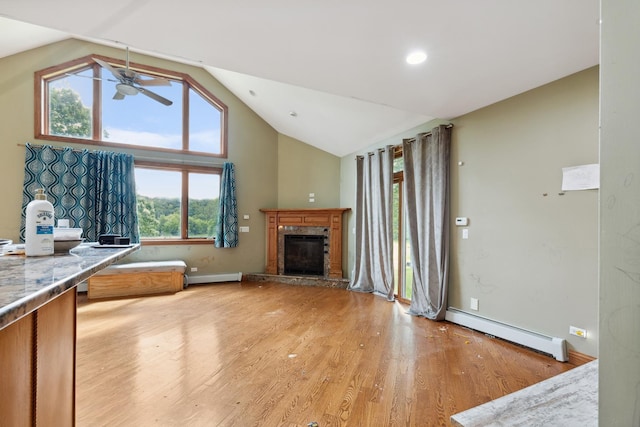 1313 Plum Tree Rd, Barrington Hills, IL 60010 - unfurnished living room with a baseboard heating unit, a ceiling fan, a glass covered fireplace, light wood-style flooring, and high vaulted ceiling