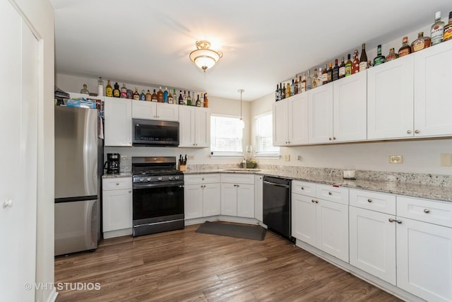 1811 Prairie Ridge Dr, Plainfield, IL 60586 - kitchen with appliances with stainless steel finishes, white cabinets, dark wood-style floors, pendant lighting, and light stone countertops