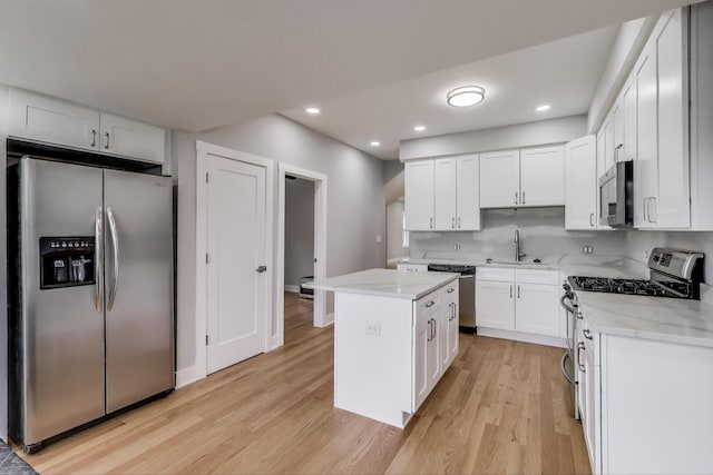 5735 S Fairfield Ave, Chicago, IL 60629 - kitchen featuring appliances with stainless steel finishes, light wood-style flooring, a center island, white cabinetry, and recessed lighting