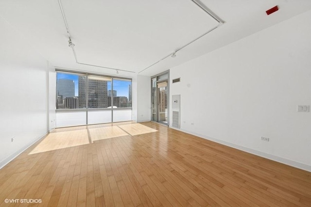 8 E Randolph St Unit 3007, Chicago, IL 60601 - spare room with rail lighting, light wood-type flooring, and a wall of windows