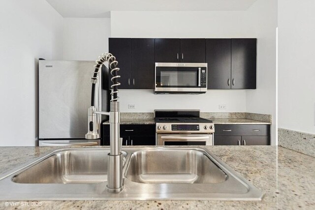 8 E Randolph St Unit 3007, Chicago, IL 60601 - kitchen featuring stainless steel appliances, dark cabinets, and light countertops