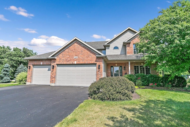 29990 Fehmarn Way, Genoa, IL 60135 - traditional-style house with brick siding, a garage, a front yard, asphalt driveway, and roof with shingles