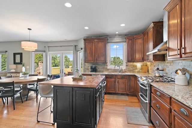 29990 Fehmarn Way, Genoa, IL 60135 - kitchen featuring double oven range, plenty of natural light, wall chimney range hood, light wood-type flooring, and recessed lighting